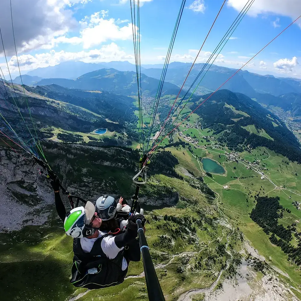 Vol en parapente au-dessus des paysages des Aravis, offrant une vue panoramique spectaculaire.