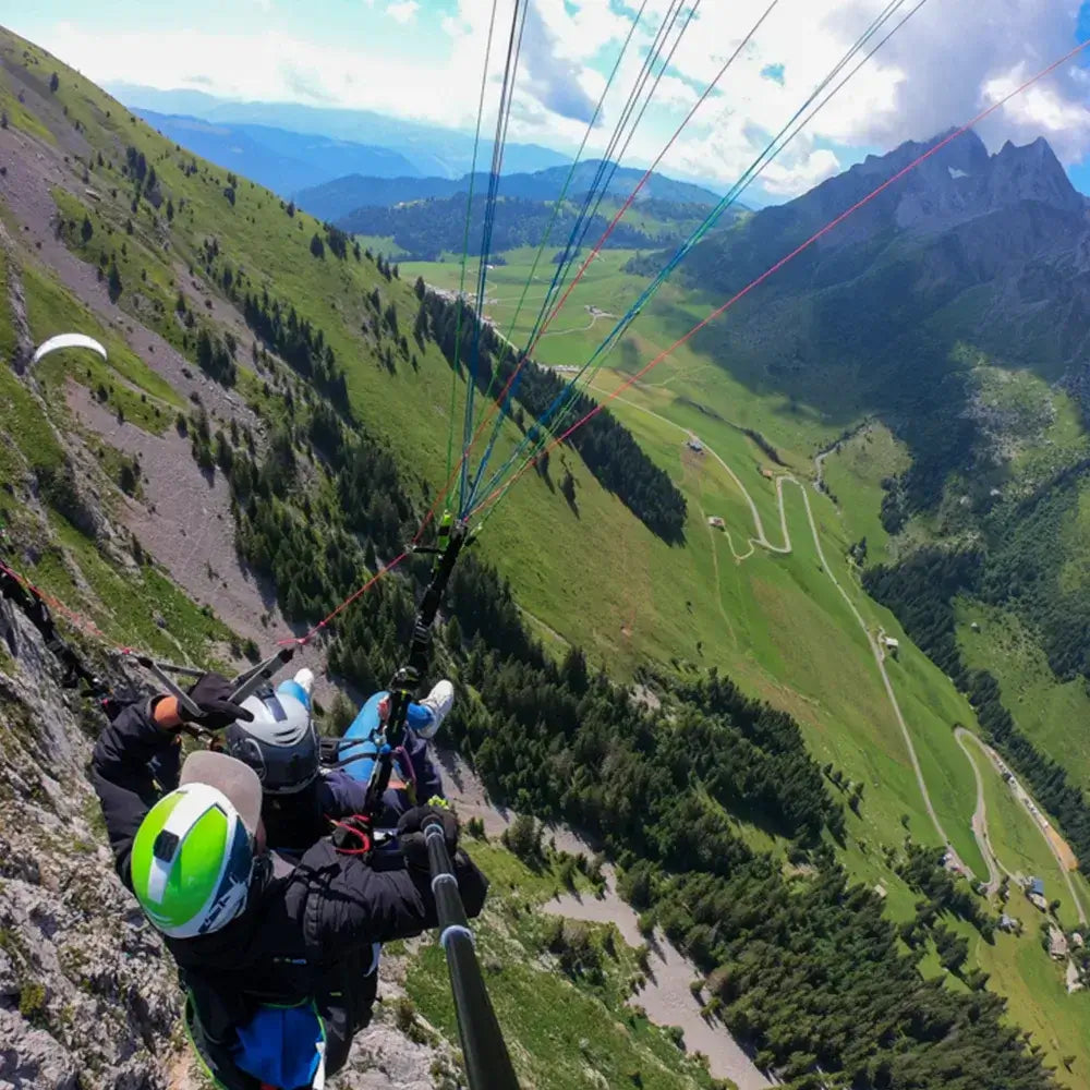 Paraglider soaring over the Aravis mountains during a paragliding experience in La Clusaz, showcasing scenic views.