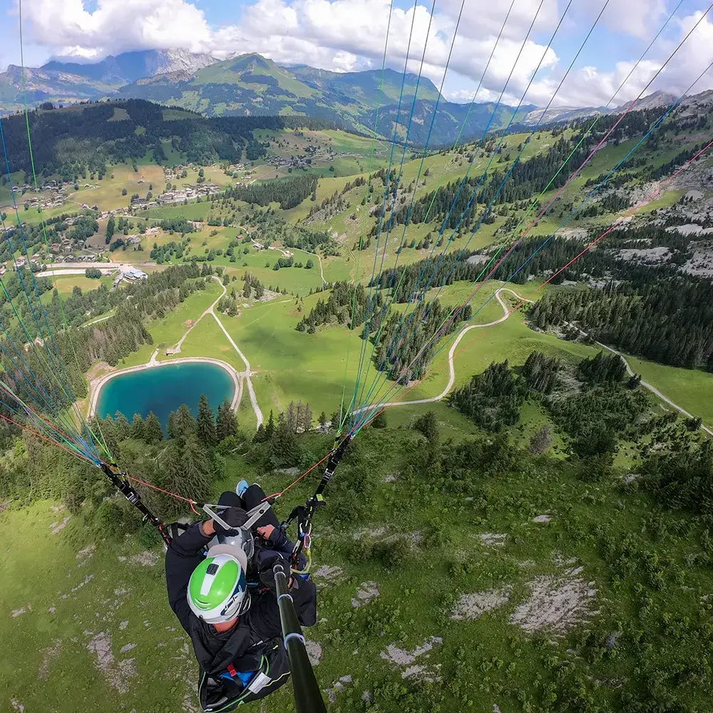 Vue panoramique lors d'un vol en parapente au-dessus des paysages verdoyants des Aravis.