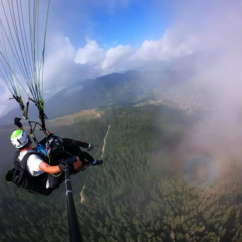 Parapente au-dessus des forêts, survolant les Aravis lors d'un vol panoramique.